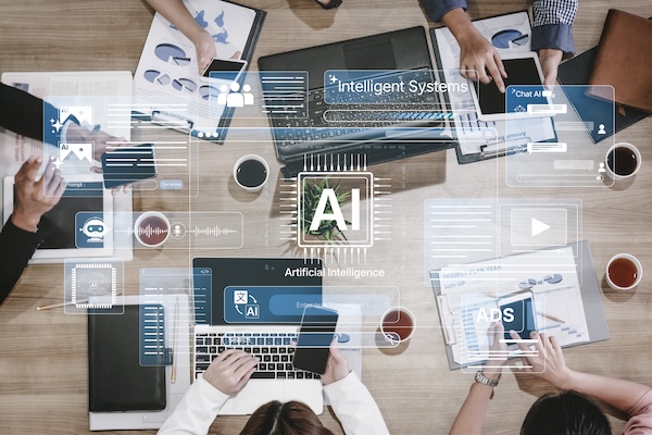 Team working around a table with laptops and AI technology graphics