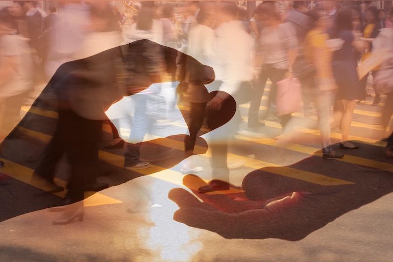 Hands of a man giving heart to women with street background